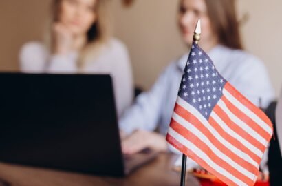 Young female travel agent consultant in tour agency holding magazine